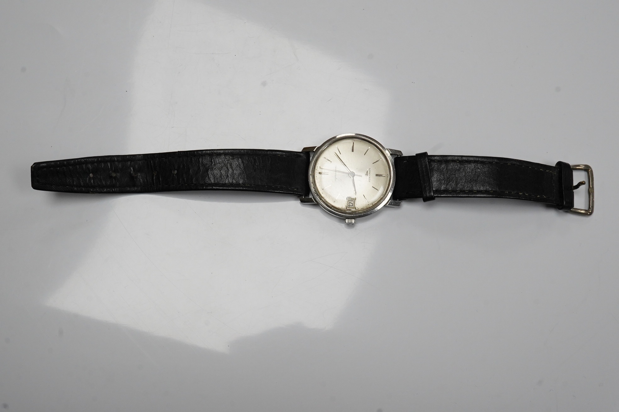 A gentleman's stainless steel Longines automatic wrist watch, with baton numerals and date aperture, case diameter 35mm, on an associated leather strap. Condition - poor